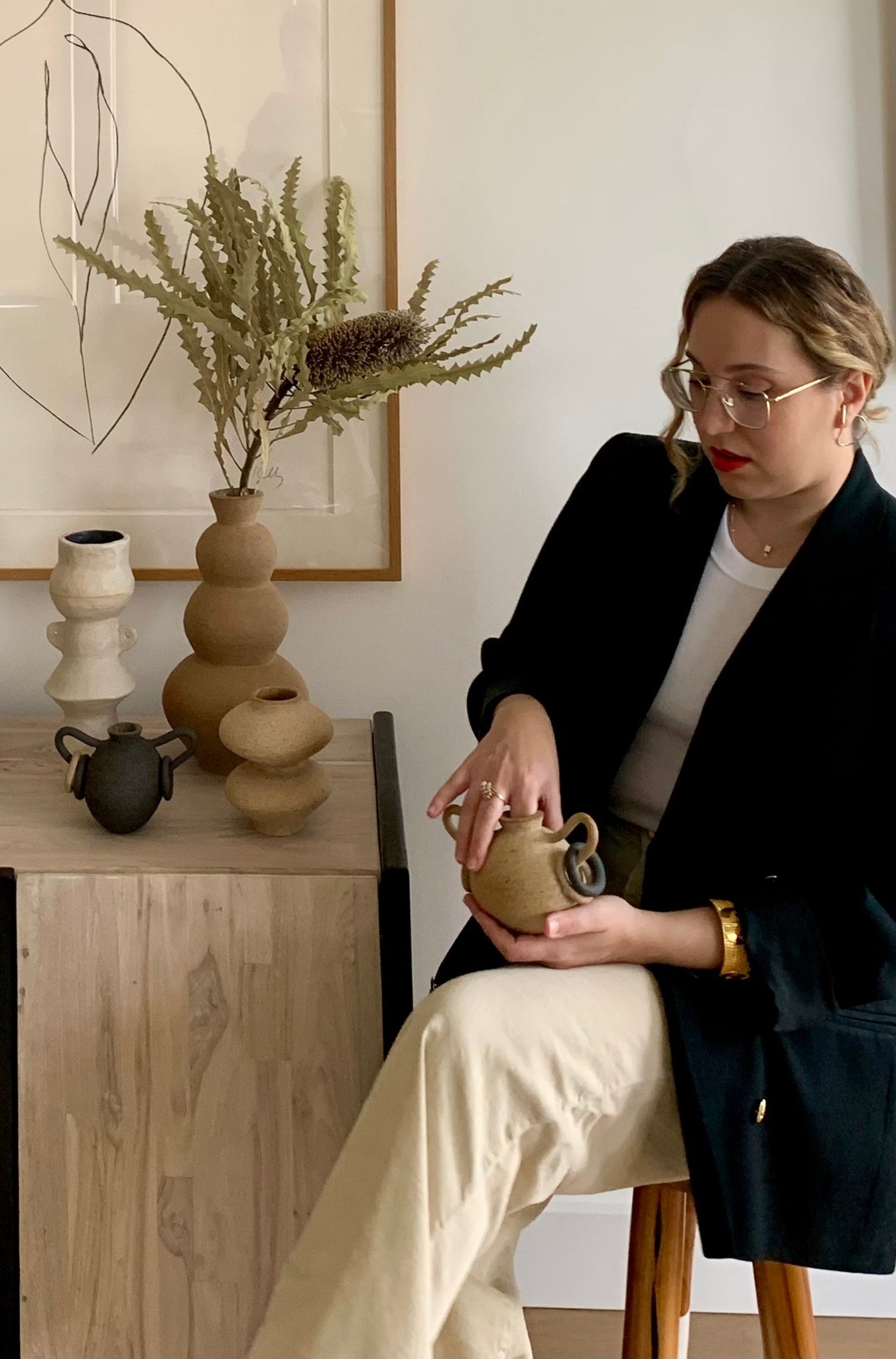 Taylor Ruby Bell holding her beige ceramic vase