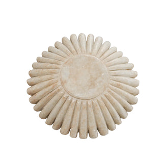Decorative stone bowl with sunburst design on a white background