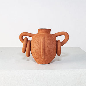 Terracotta vase with spiral handles on a white background