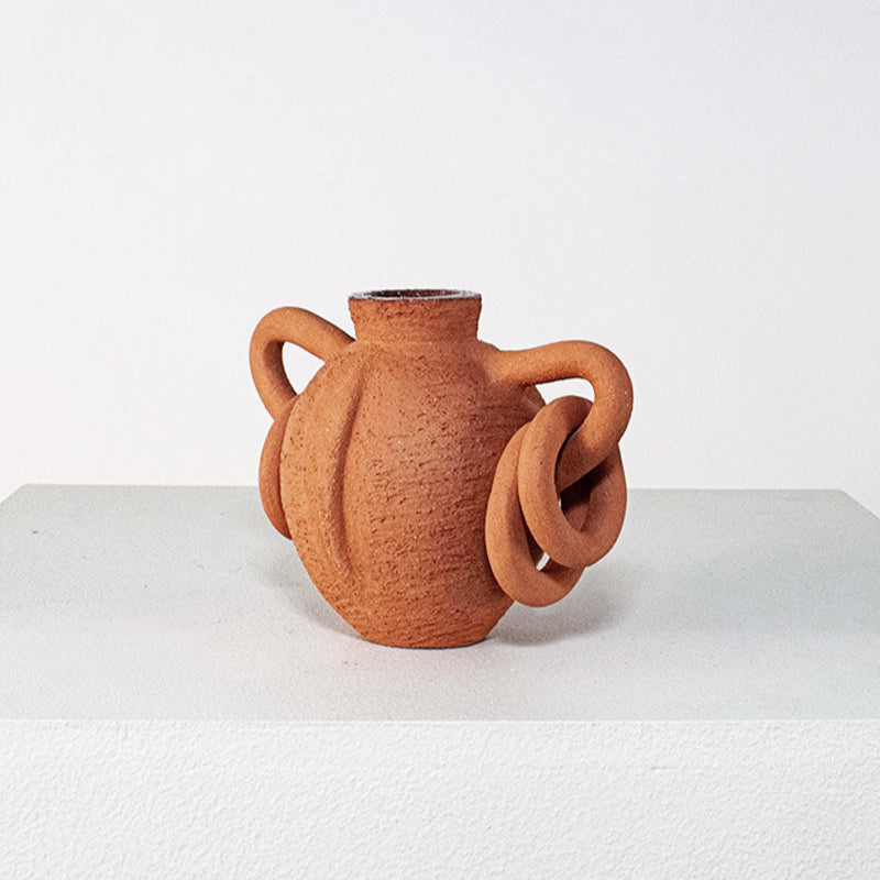 Terracotta vase with twisted handles on a white background
