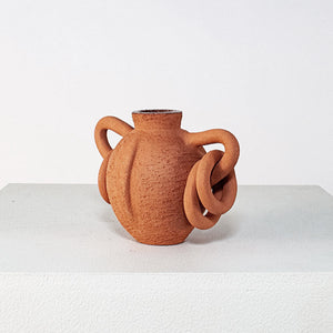 Terracotta vase with twisted handles on a white background