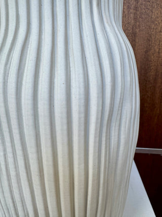 White ribbed vase on wood background