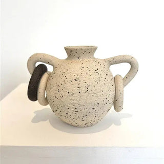 Speckled ceramic vase with two handles on a white background
