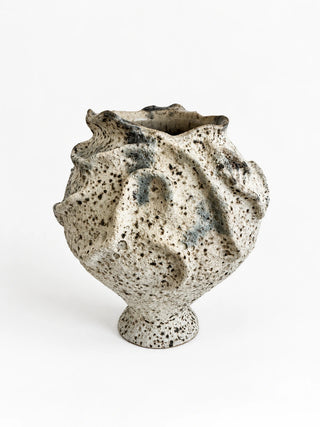 A handmade ceramic vase with a textured, organic shape and a speckled glaze, photographed on a seamless white background.