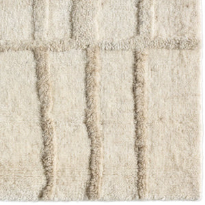 Textured beige wool rug with wavy line 