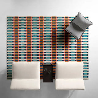 Colorful striped rug with a pillow and two white chairs on a light gray background