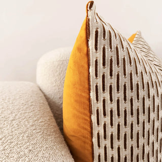 Close-up of a textured pillow with a geometric pattern on a neutral background