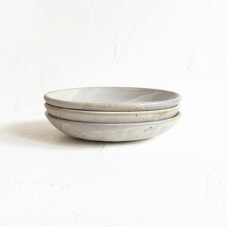 Three stacked ceramic shallow bowls in a light gray glaze with subtle brown speckles