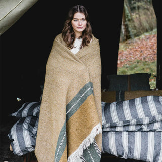 Woman wrapped in a patterned blanket standing 