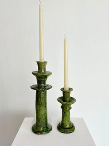 Two green candle holders with candles 