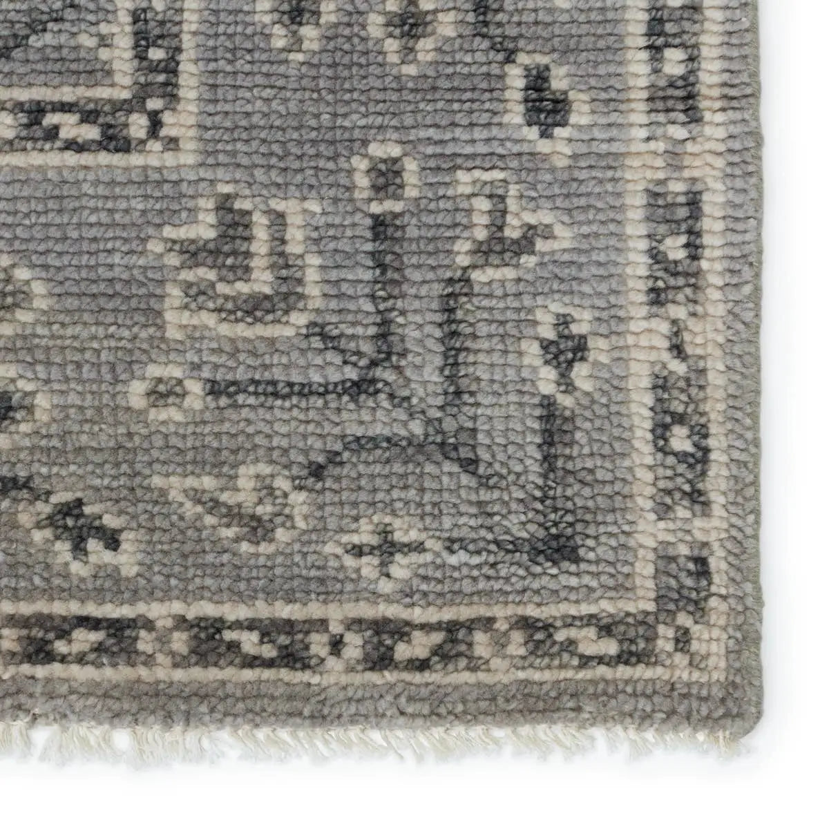 Close-up of a textured gray rug with intricate patterns 
