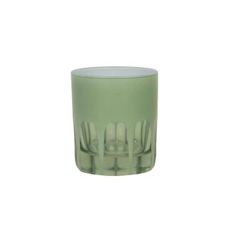 Green glass tumbler with cut-out design on a white background