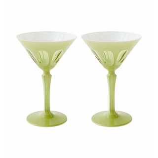 Two green martini glasses with white interiors on a white background