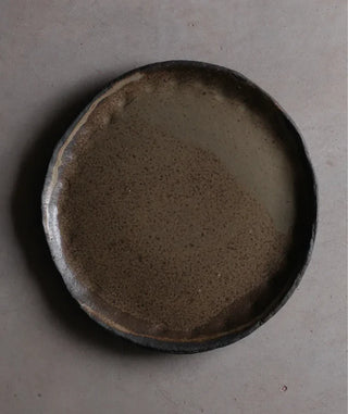 Ceramic plate with a textured surface on a gray background