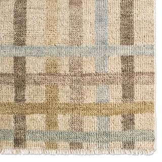 Close-up of a textured rug with a geometric pattern in earthy tones.