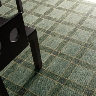 Green checkered patterned carpet with a black chair leg visible