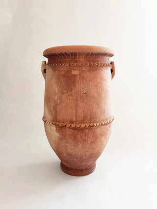 Terracotta vase with decorative patterns on a white background