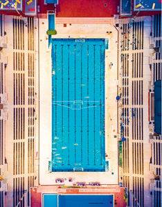 Aerial view of a swimming pool with blue water and white deck.