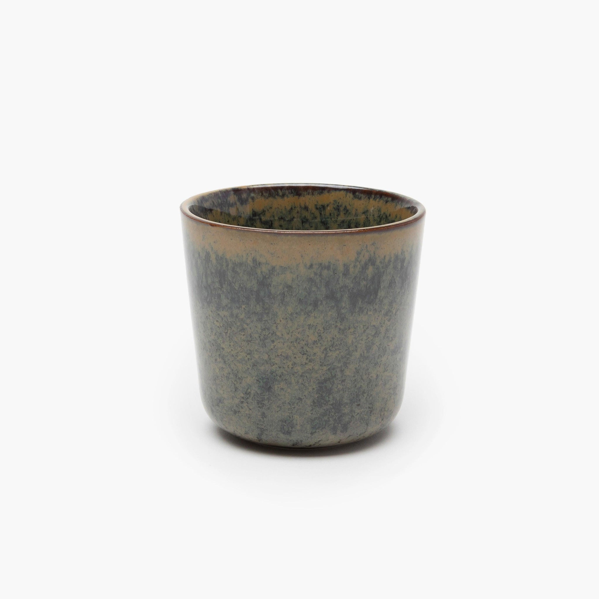 Ceramic cup with speckled design on a white background