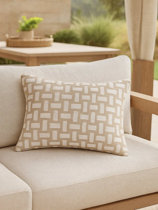 A rectangular throw pillow with a woven basketweave pattern in beige and off-white