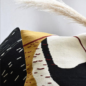 Delta square decorative throw pillow in a contemporary organic design in black cream mustard and dark maroon colors hand-woven in wool on a pedal loom in Oaxaca, Mexico.